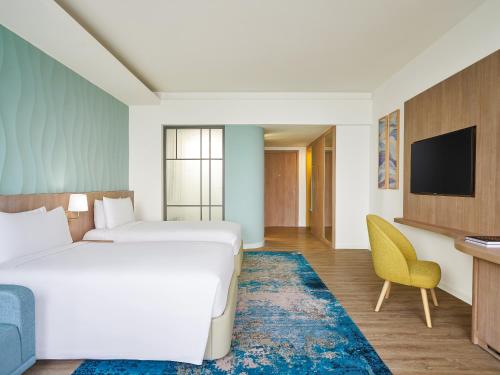 a hotel room with a bed and a tv at Holiday Inn Resort Ho Tram Beach by IHG in Ho Tram