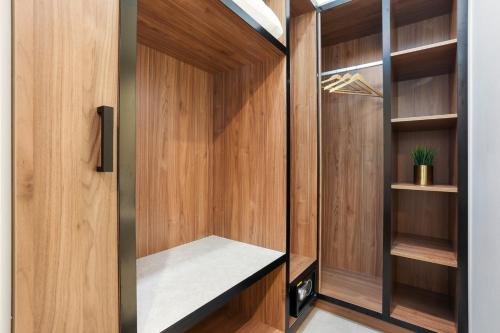 a walk in closet with wood paneling and a glass door at Killara Hotel & Suites in Killara