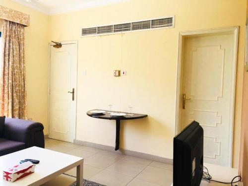 a living room with a table and a door at Majestic Hotel in Manama