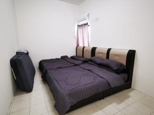 um quarto com uma cama e uma mala em Happy homestay pulau pangkor em Kampong Sungai Udang
