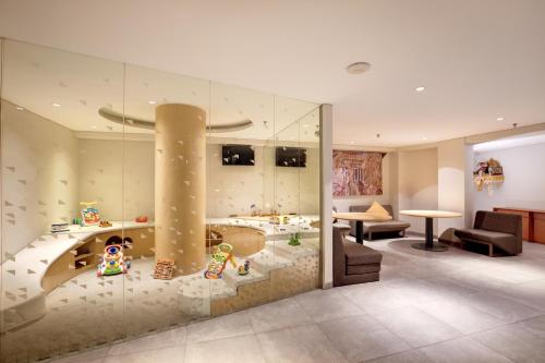 a large room with a tub and a living room at Episode Kuta Bali in Kuta