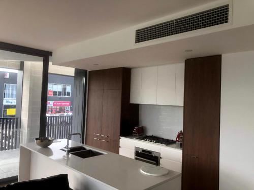 a kitchen with white cabinets and a counter top at Waters Edge Apartments in Warners Bay