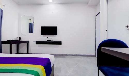 a room with a bed with a rainbow blanket at Treebo Finesta Suites, Nagpur Airport in Nagpur