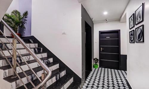 a hallway with stairs and a black door at Treebo Finesta Suites, Nagpur Airport in Nagpur