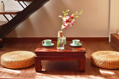 a table with two cups and a vase with flowers at CHERRY BOUTIQUE HOTEL in Ho Chi Minh City