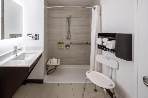 a white bathroom with a shower and a sink at Holiday Inn Express - Coventry S - West Warwick Area by IHG in Coventry