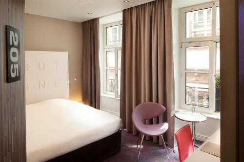 Ένα ή περισσότερα κρεβάτια σε δωμάτιο στο Hôtel Gutenberg