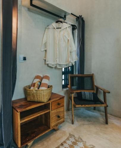 a room with a chair and a table with baskets on it at Ambre & Epices Jungle Hotel & Spa in Tulum
