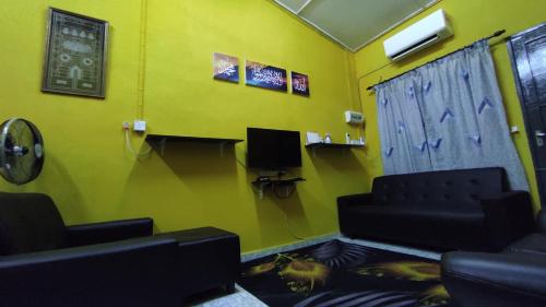 a waiting room with two chairs and a tv at Homestay Opah Parit Buntar, Perak in Parit Buntar