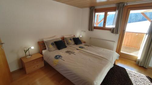 a bedroom with a bed with white sheets and a window at Loch673 in Schwarzenberg