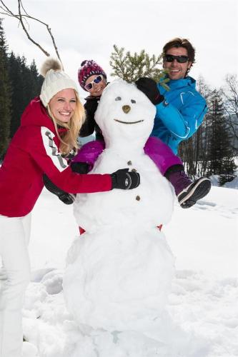 a group of people standing next to a snowman at Aue, Ferienwohnung in Tux