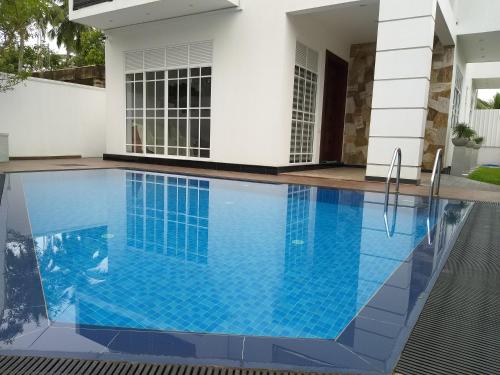 a swimming pool in front of a house at White Castle in Wadduwa