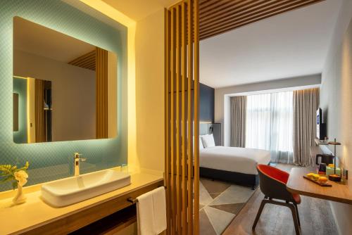a bathroom with a bed and a sink and a mirror at Holiday Inn Express Qingdao Jinshui, an IHG Hotel in Qingdao