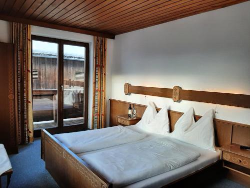 a bedroom with a large bed and a balcony at Bauernhof Burglehen in Wagrain