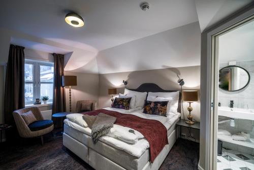 1 Schlafzimmer mit einem großen Bett und einem Badezimmer in der Unterkunft Aksjemøllen - by Classic Norway Hotels in Lillehammer