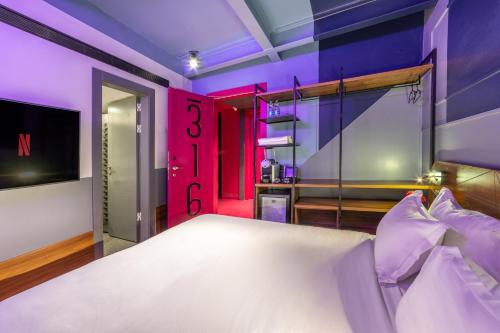 a bedroom with a large white bed with purple walls at Stay Inn Hotel Jerusalem in Jerusalem