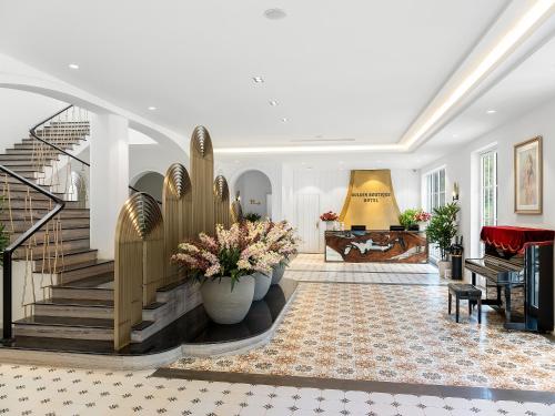 a living room with a staircase and a couch at Golden Sun Hotel - Mangden in Kon Tum