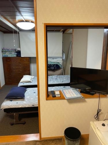 a mirror reflecting a bedroom with two beds and a desk at Live Cafe Hisui no Umi in Itoigawa