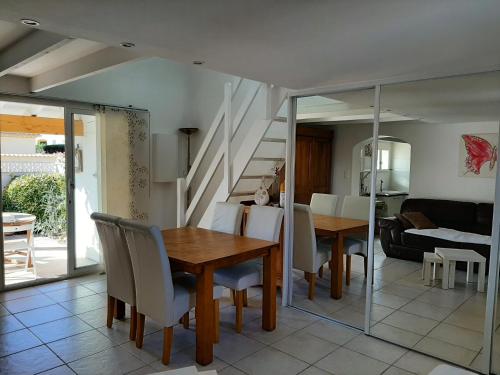 une salle à manger et un salon avec une table et des chaises dans l'établissement Location maison 4 pers Le Grau d'Agde 34, au Grau-dʼAgde