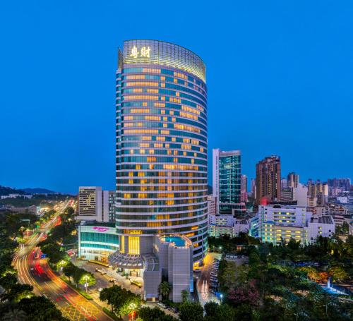 Crowne Plaza Zhuhai City Center, an IHG Hotel في تشوهاى: مبنى طويل في مدينة في الليل