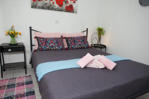 a bed with two pink towels on top of it at Ariadne 1, Sea Side Boutique Apartment in Limassol