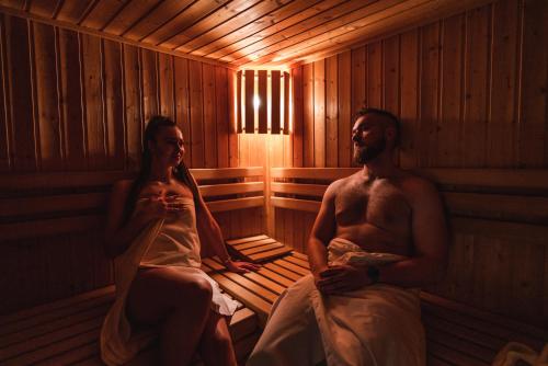 a man and a woman sitting in a sauna at Penzión Solisko*** Oščadnica in Oščadnica