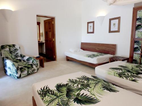 a hotel room with two beds and a chair at Gecko Resort in Watamu