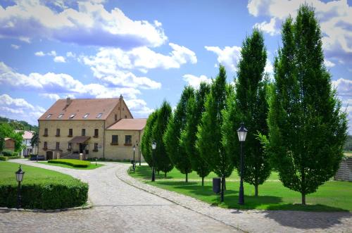 uma fila de árvores em frente a um edifício em Folwark Pszczew em Pszczew