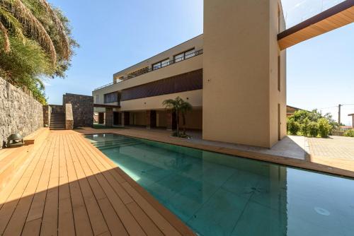 a swimming pool in front of a house at Sicilia's Art Hotel & Spa in Acitrezza