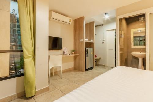 a hotel room with a bed and a bathroom at Matini Ratchada 32 in Bangkok