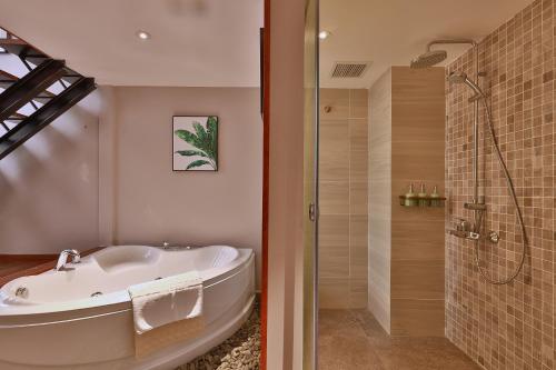 a bathroom with a bath tub and a shower at CHERRY BOUTIQUE HOTEL in Ho Chi Minh City
