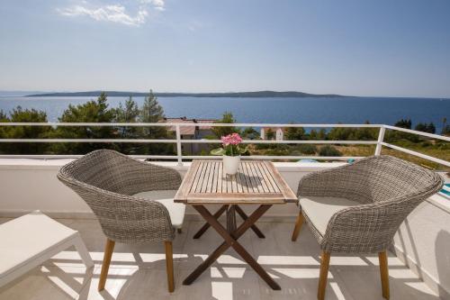 a table and chairs on a balcony with a view of the water at Stella Mare Eco Boutique House in Zavala