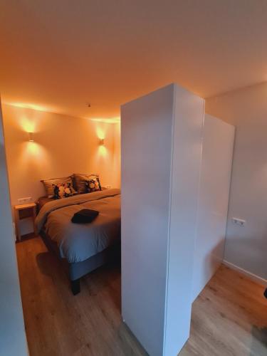 een slaapkamer met een bed en een witte kast bij Studio Baarn with patio, airco, pantry, bedroom, bathroom, privacy - Amsterdam, Utrecht in Baarn