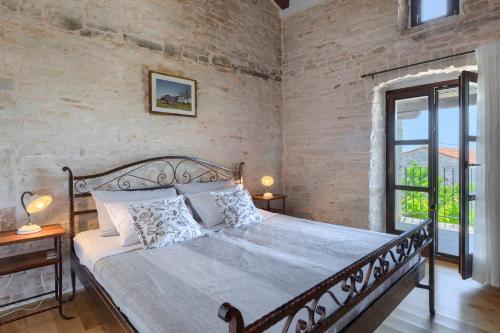 Un dormitorio con una cama y una pared de ladrillo. en Villa Paulina -an authentic sense of Istrian life, en Gajana