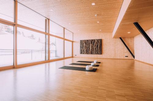 a room with yoga mats in a room with windows at Naturhotel Chesa Valisa in Hirschegg