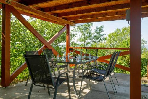 une table et des chaises en verre sur la terrasse dans l'établissement Panoráma Apartmanház, à Esztergom