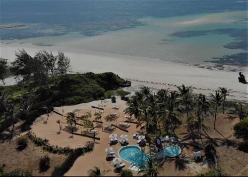 an aerial view of a beach with chairs and umbrellas at Gecko Resort in Watamu