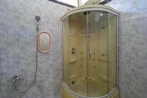 y baño con ducha y puerta de cristal. en KoolKost Syariah At Komplek PLN Balikpapan, en Balikpapan