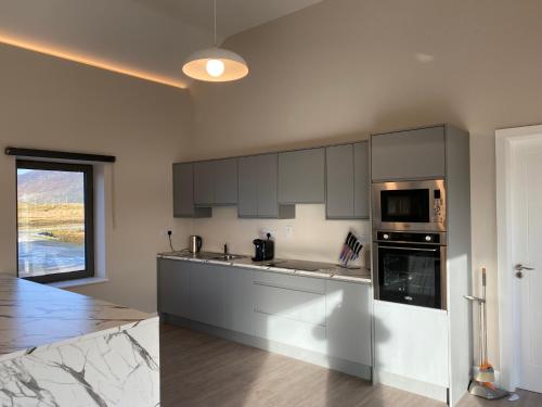 a kitchen with gray cabinets and a counter top at Cottage 421 - Letterfrack in Letterfrack
