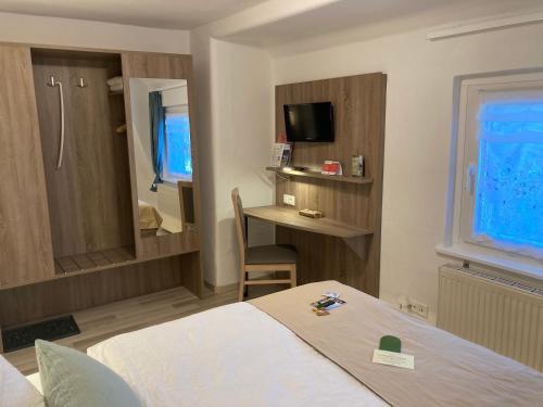 a hotel room with a bed and a desk in it at Pension Lachmann in Pfaffendorf