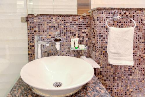 a bathroom with a white sink and a towel at Hotel Dreamland Chandigarh in Chandīgarh