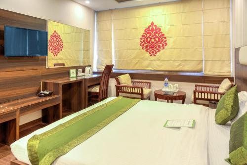 a room with a bed and a table and chairs at Hotel Dreamland Chandigarh in Chandīgarh