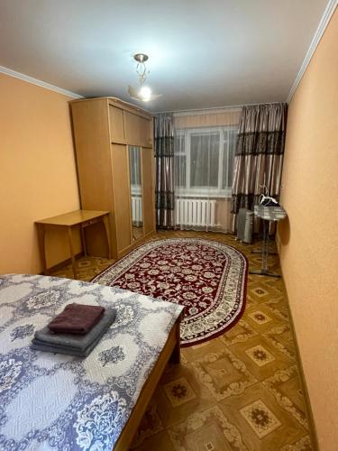 ein Schlafzimmer mit einem Bett und einem großen Teppich in der Unterkunft 2-х комнатная Ауезова in Öskemen
