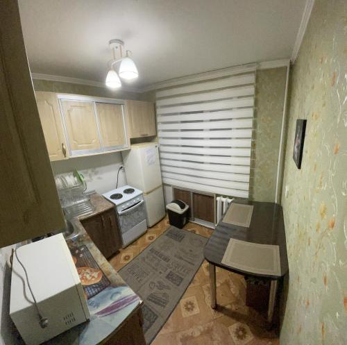 eine kleine Küche mit einem Tisch und einem Kühlschrank in der Unterkunft 2-х комнатная Ауезова in Öskemen