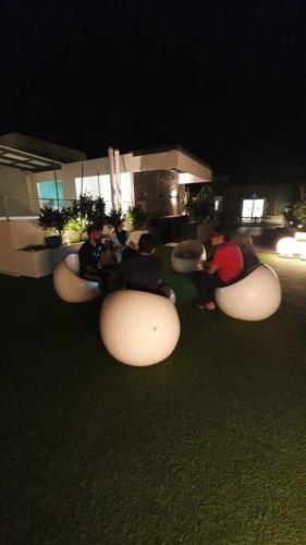 a group of people sitting in bean chairs at night at myRumah Imperio Home , Alor Setar 3BR with Sky Infinity Pool in Alor Setar