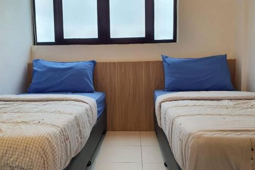 two beds in a room with blue pillows at myRumah Imperio Home , Alor Setar 3BR with Sky Infinity Pool in Alor Setar
