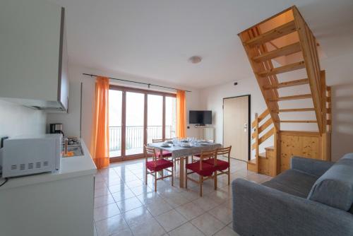 a kitchen and living room with a table and chairs at Residence Dorio in Dorio