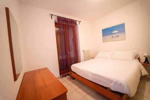 a bedroom with a bed and a table and a window at Residence Dorio in Dorio
