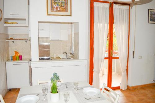 a dining room with a table and a kitchen at Homiday - Appartamenti Pinetina in Pineto