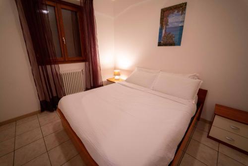 a bedroom with a bed with white sheets and pillows at Residence Dorio in Dorio